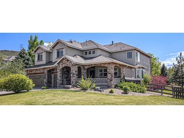 Charming two-story home with a stone facade, covered porch, landscaped yard, and attached two-car garage at 19096 W 53Rd Pl, Golden, CO 80403