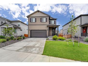 Charming two-story home featuring a well-manicured lawn, complemented by an attached two-car garage and a welcoming front porch at 933 Canal West Dr, Brighton, CO 80603