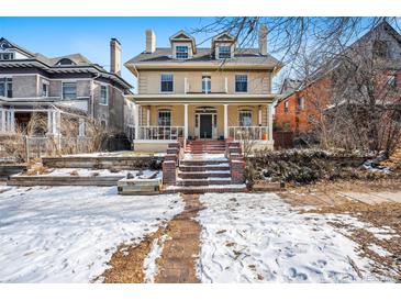 Stunning two-story home featuring brick steps, a covered porch with white columns, and dormer windows at 1368 N Gilpin St, Denver, CO 80218