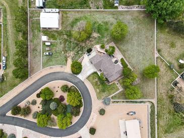 Stunning aerial view of a home with large yard, circular driveway and outbuildings on an oversized lot at 3784 Whitetail Ct, Mead, CO 80542