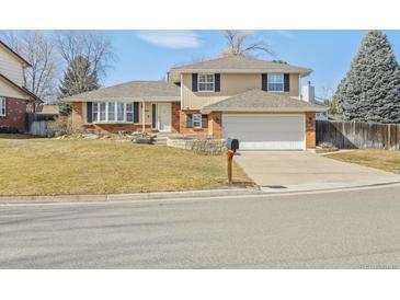 Charming two-story home with brick and siding exterior, a well-maintained lawn, and an attached two-car garage at 7867 S Poplar Way, Centennial, CO 80112