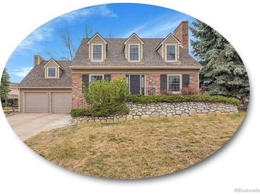 Charming brick home featuring a manicured front lawn and an attached two car garage at 7426 S Hudson Way, Centennial, CO 80122