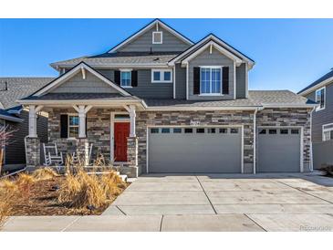 Charming two-story home with stone accents, grey siding, and an inviting front porch at 4104 N Picadilly Ct, Aurora, CO 80019