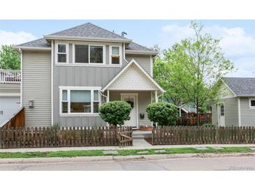 Charming two-story home features a quaint front porch and a decorative picket fence at 208 N Foote Ave, Lafayette, CO 80026