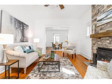 Bright living room boasts a stone fireplace, hardwood floors, and neutral decor for a cozy feel at 1723 E 16Th Ave, Denver, CO 80218