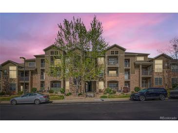 Inviting condo building with well-maintained landscaping and multiple balconies under a beautiful pink sunset at 2985 Blue Sky Cir # 7-107, Erie, CO 80516