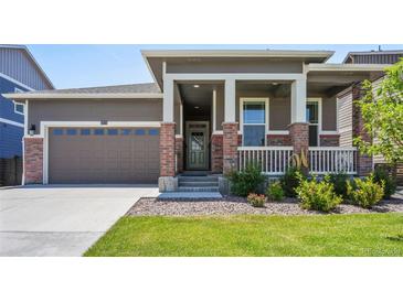 Brick ranch home with front porch and landscaped lawn at 26774 E Archer Ave, Aurora, CO 80018