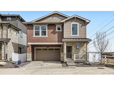 Two-story home featuring a two-car garage, stone accents, and covered entry at 2098 S Haleyville Way, Aurora, CO 80018