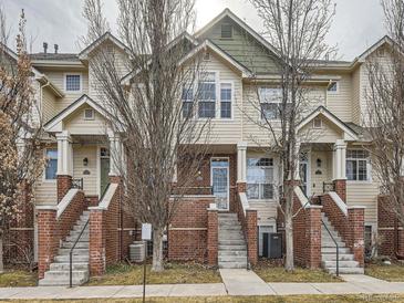 Inviting townhome with a well-maintained exterior, including a brick facade and landscaped entrance at 9813 E Carolina Pl, Aurora, CO 80247