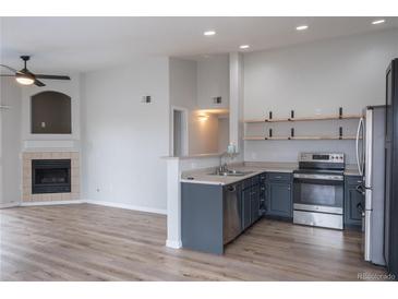 Modern kitchen features stainless steel appliances, open shelving, and ample counter space at 10035 E Carolina Pl # 201, Aurora, CO 80247