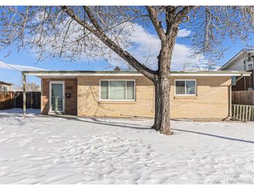 Ranch style home with brick exterior, front door, and snowy yard at 7674 Stuart St, Westminster, CO 80030