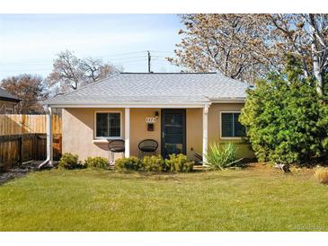 Charming single-story home featuring a well-manicured lawn and inviting front porch with seating at 1171 Quebec St, Denver, CO 80220