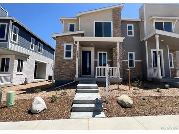 Inviting two-story home featuring stone accents, neutral tones, and well-manicured landscaping at 6638 N Nepal Ct, Aurora, CO 80019