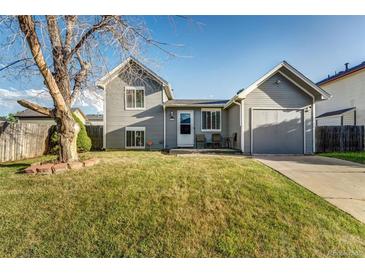 Charming home featuring a well-maintained lawn, a garage, and inviting curb appeal at 16980 E Stanford Ave, Aurora, CO 80015