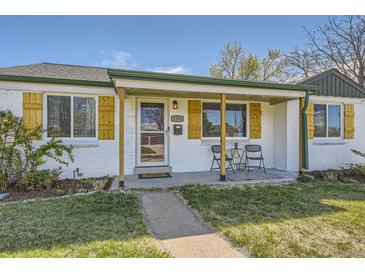 Charming white brick home with a cozy front porch and natural wood accents at 1374 S Beach Ct, Denver, CO 80219