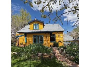Charming yellow home with unique architectural details and lush front yard landscaping at 2320 22Nd St, Boulder, CO 80304