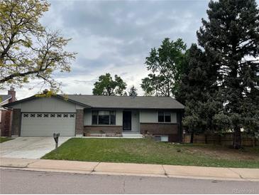 Charming single-story home with an attached garage and a well-maintained front lawn at 4115 S Vincennes Ct, Denver, CO 80237