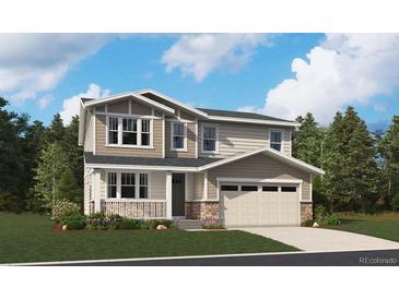 Two-story home with a front porch, two-car garage, and stone accents on the facade at 4575 Thistle Dr, Brighton, CO 80601