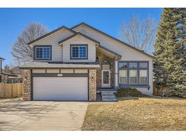 Charming two-story home features a stone-accented facade, attached garage, and well-maintained front yard at 5331 S Dunkirk Way, Centennial, CO 80015