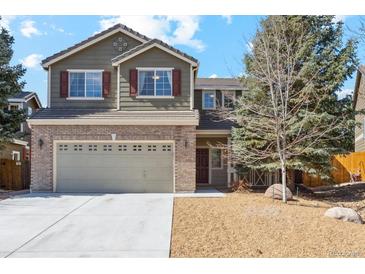 Charming two-story home featuring a well-maintained lawn, brick accents, and an attached two-car garage at 7453 S Norfolk St, Aurora, CO 80016