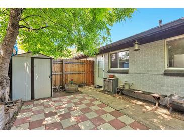 Cozy backyard patio featuring red and white checkered pavers, a storage shed, and a charming wooden bench at 2955 N Gilpin St, Denver, CO 80205