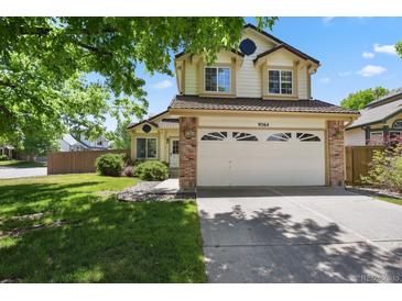 Charming two-story home with a manicured front yard, and a two car garage, showing great curb appeal at 9564 Cordova Dr, Highlands Ranch, CO 80130