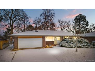 Charming ranch-style home with brick and siding exterior, snow-covered yard, and attached two-car garage at 2842 S Newport St, Denver, CO 80224