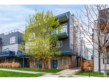 Modern townhouse featuring a blue accented exterior, complemented by fresh spring foliage and a well-manicured lawn at 1941 Hooker St, Denver, CO 80204
