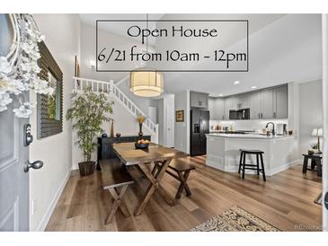 Bright living room boasts wooden floors, a modern kitchen with grey cabinets, and a staircase to the upper level at 2528 Concord Cir, Lafayette, CO 80026