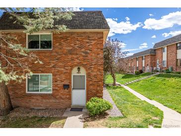 Charming brick townhouse featuring a well-maintained lawn and inviting front entrance at 4663 S Lowell Blvd, Denver, CO 80236