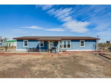 Charming blue home featuring an inviting patio and a well-maintained landscape at 16491 County Road 32, Platteville, CO 80651