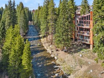 Riverside condo with balconies and ample natural light, surrounded by lush greenery at 805 Columbine Rd # 202, Breckenridge, CO 80424