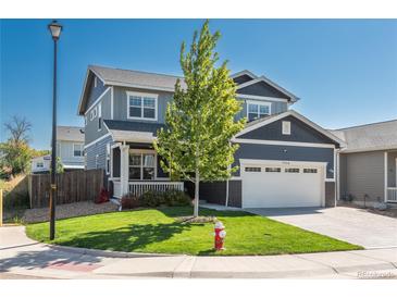 Charming two-story home with a well-manicured lawn, attached two-car garage, and inviting front porch at 7958 Tejon St, Denver, CO 80221