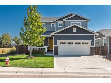 Attractive two-story home with a two-car garage, a green lawn, and a bright, inviting yellow front door at 7958 Tejon St, Denver, CO 80221