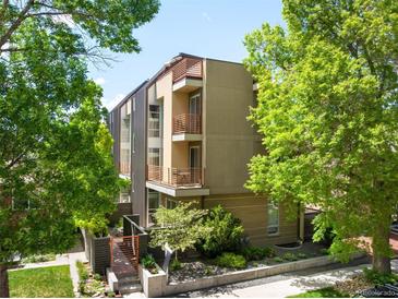 Modern, multi-story condo building with balconies and manicured landscaping on a sunny day at 33 S Ogden St, Denver, CO 80209
