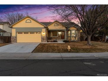 Charming single Gathering home featuring a two-car garage, stone accents, and a well-maintained front yard at 12776 Yates Cir, Broomfield, CO 80020