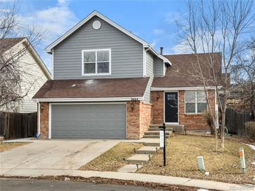 Charming two-story home with a gray exterior, brick accents, and an attached two-car garage at 2664 S Halifax Ct, Aurora, CO 80013