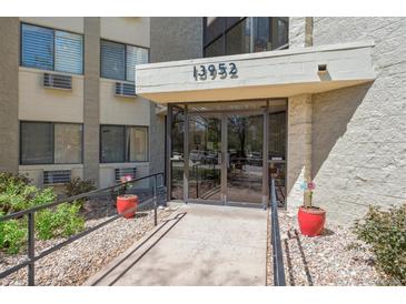 Building entrance featuring a ramp with handrails and glass doors under a canopy with the building's address at 13952 E Marina Dr # 509, Aurora, CO 80014