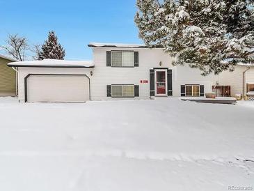 Charming split-level home with a two-car garage and snow-covered front yard at 9135 W Maplewood Ave, Littleton, CO 80123