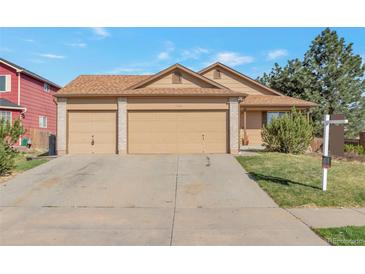 Charming single-story home showcasing a large driveway and attached two-car garage at 5106 Eagle Ct, Denver, CO 80239