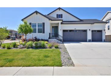 Charming home with modern white siding, dark trim, and a two-car garage, plus a lovely manicured front yard at 1160 Spencer Pl, Erie, CO 80026