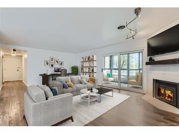 Bright living room with modern furnishings, fireplace and a sliding glass door to the balcony at 800 Pearl St # 204, Denver, CO 80203