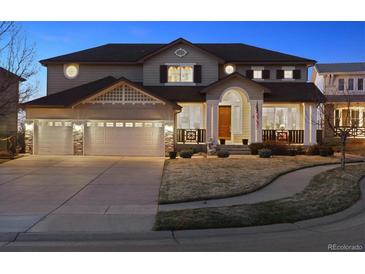 Beautiful two-story home featuring a three-car garage, well-maintained lawn, and inviting front porch at 1015 Graland Pl, Highlands Ranch, CO 80126