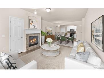 Bright, staged living room featuring a fireplace, modern decor, and open layout to the dining area and kitchen at 9397 Las Ramblas Ct # D, Parker, CO 80134