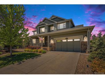 Charming two-story home with well-maintained landscaping, inviting porch, and two car garage at 26004 E Elmhurst Pl, Aurora, CO 80016