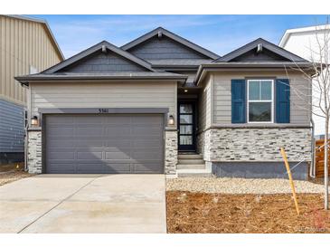 Charming single-Gathering home with a gray garage door, stone accents, and blue shutters at 3361 N Buchanan Way, Aurora, CO 80019