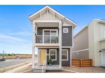 Charming two-story home with a balcony and a welcoming yellow front door at 13029 E 103Rd Pl, Commerce City, CO 80022