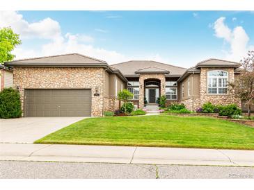 Beautiful stone and stucco home featuring an attached garage and professionally landscaped yard at 12467 Topaz Vista Way, Castle Pines, CO 80108