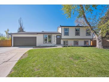 Charming two-story home boasts fresh landscaping and a large, well-maintained front lawn at 8004 S Field St, Littleton, CO 80128