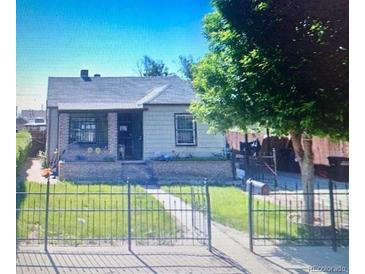 Ranch style home with a well-maintained lawn and metal fence at 645 S Perry St, Denver, CO 80219